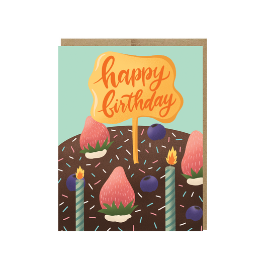 Happy birthday card tag on chocolate cake with strawberries and candles