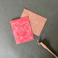 Merry Christmas card in red and with calligreaphy and flower drawing and envelope and pen